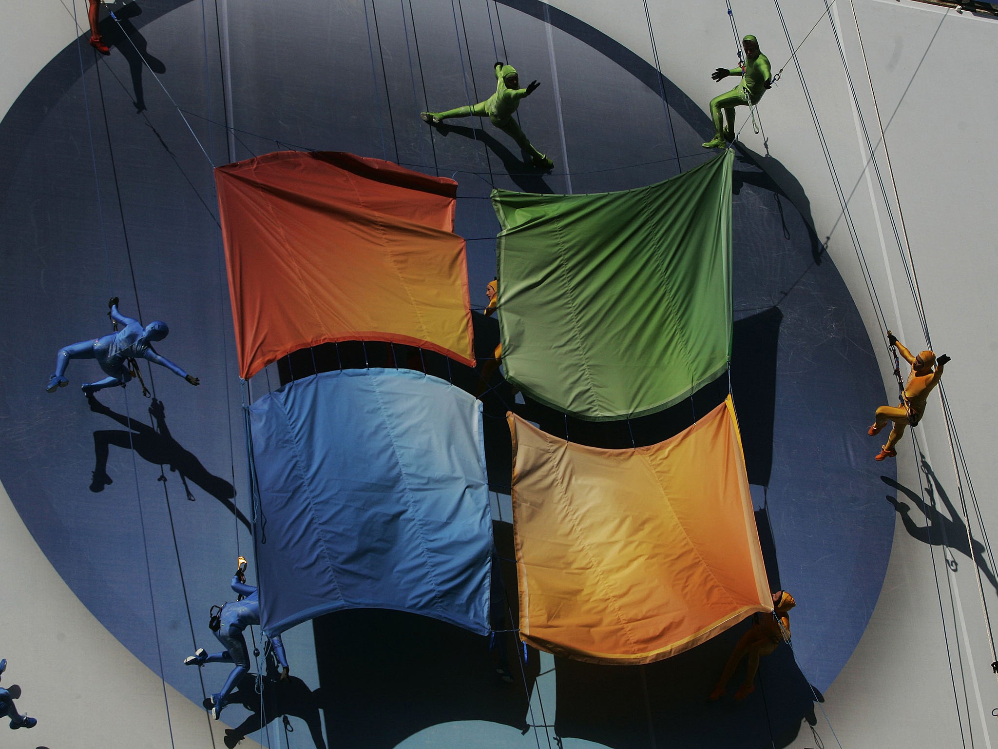 Members of the 'GROUNDED Aerial Dance Theater' hang from ropes and dance on a poster promoting Vista, a new version of Microsoft Windows, on the side of a warehouse building on Manhattan's west side January 29, 2007 in New York