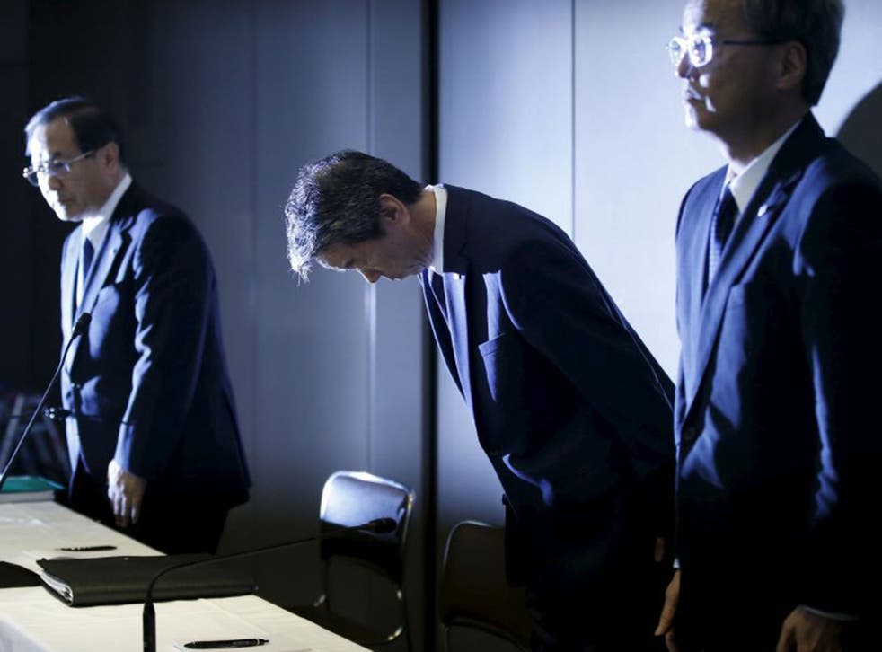 Toshiba Corp President and Chief Executive Officer Hisao Tanaka (C), flanked by Chairman of the Board Masashi Muromachi (L) and Corporate Executive Vice President Keizo Maeda, bows at the start of a news conference at the company headquarters in Tokyo Jul