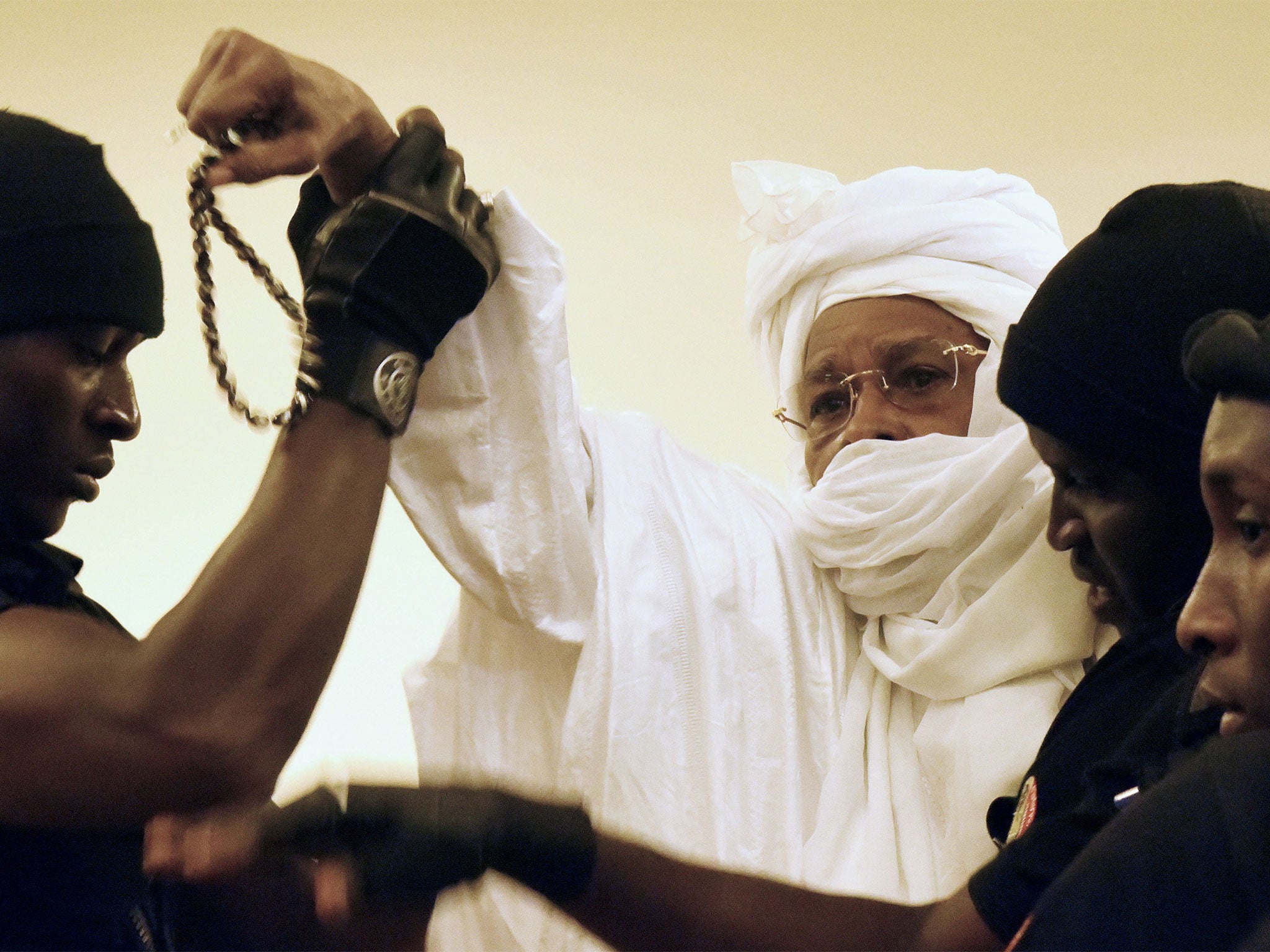 Former Chadian dictator Hissene Habre is escorted by prison guards into the courtroom for the first proceedings of his trial by the Extraordinary African Chambers in Dakar on July 20, 2015