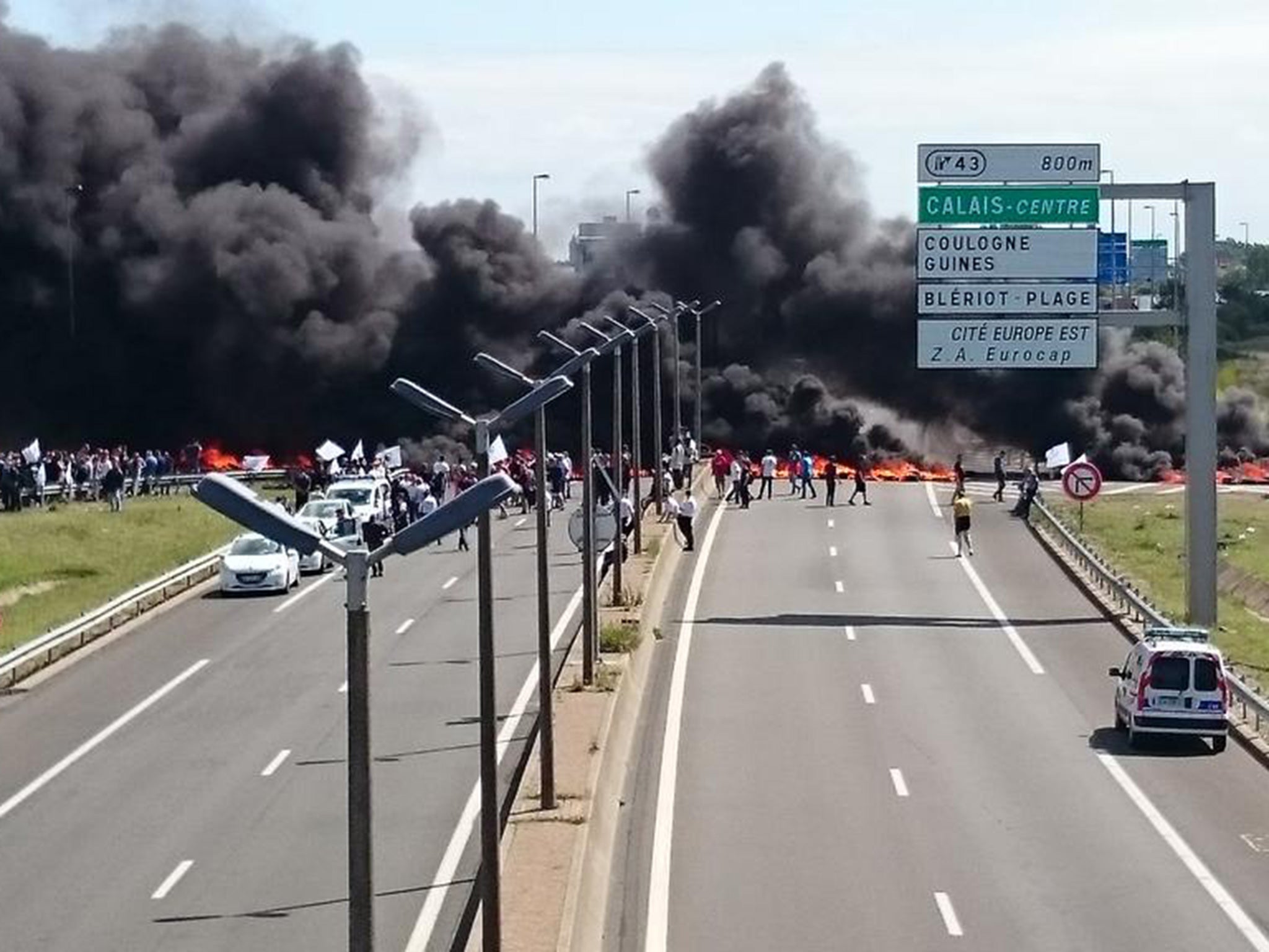 Smoke rises from where ferry workers reportedly burned tyres as they blocked access to Calais