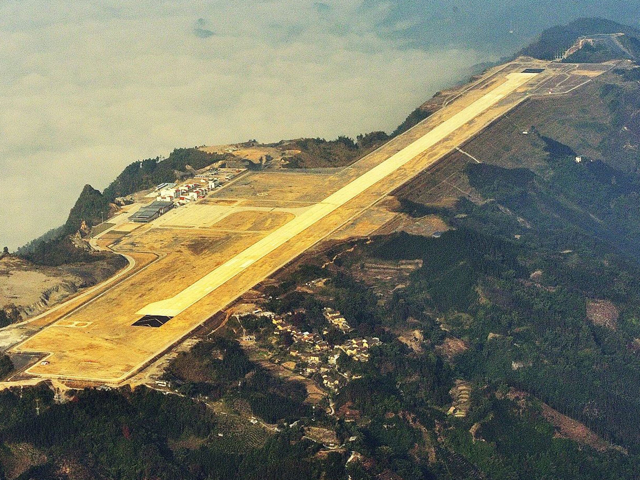 A view of the runway of the new airport built on top of mountains in Hechi city