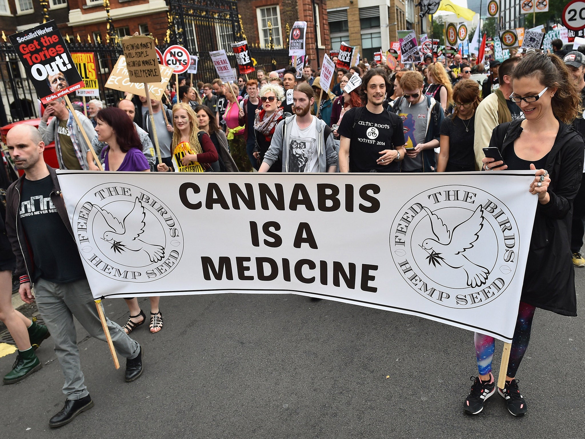 Protesters carry a banner in support of cannabis legalisation through central London during a demonstration in London last month (Getty)