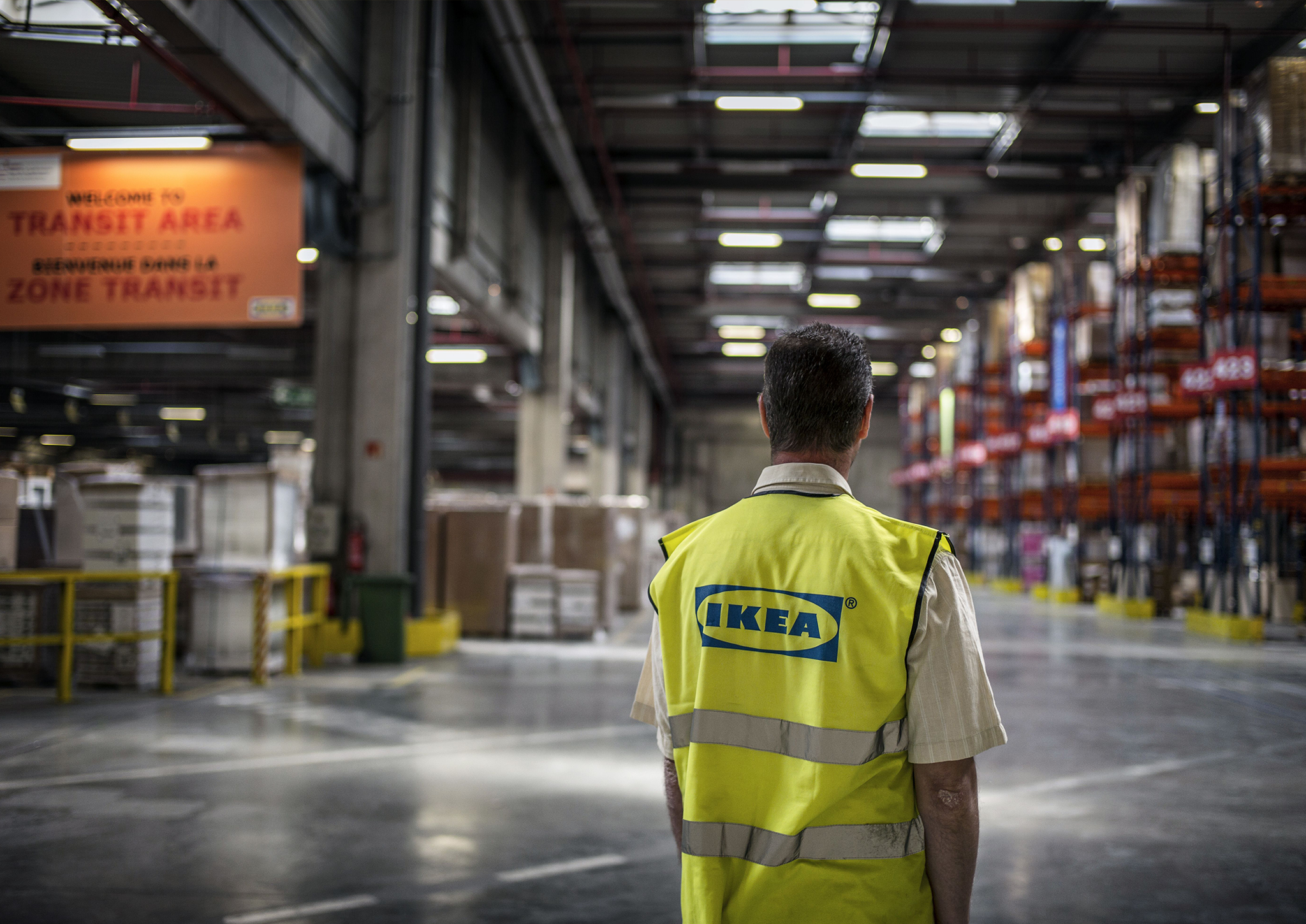 An Ikea employee gazes into the abyss of an Ikea warehouse