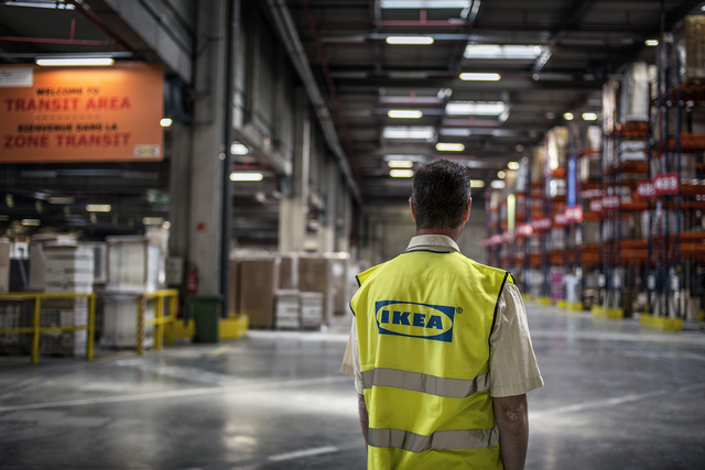An Ikea employee gazes into the abyss of an Ikea warehouse