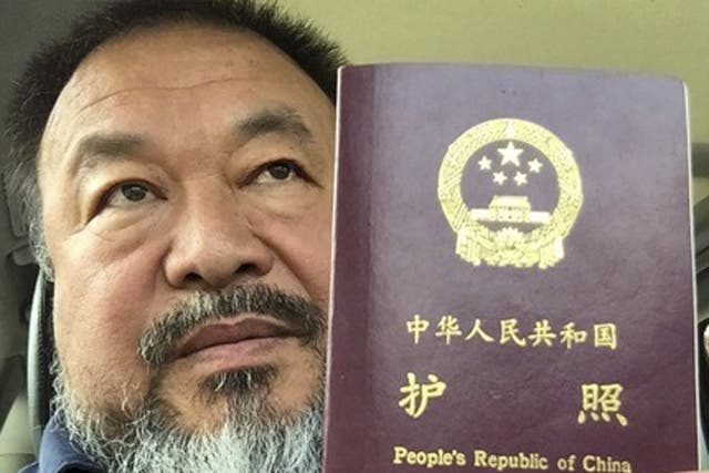 Chinese dissident artist Ai Weiwei poses with his passport in Beijing. Chinese dissident artist and free speech advocate said that authorities in Beijing returned his passport, more than four years after it was confiscated following his 81-day secret dete