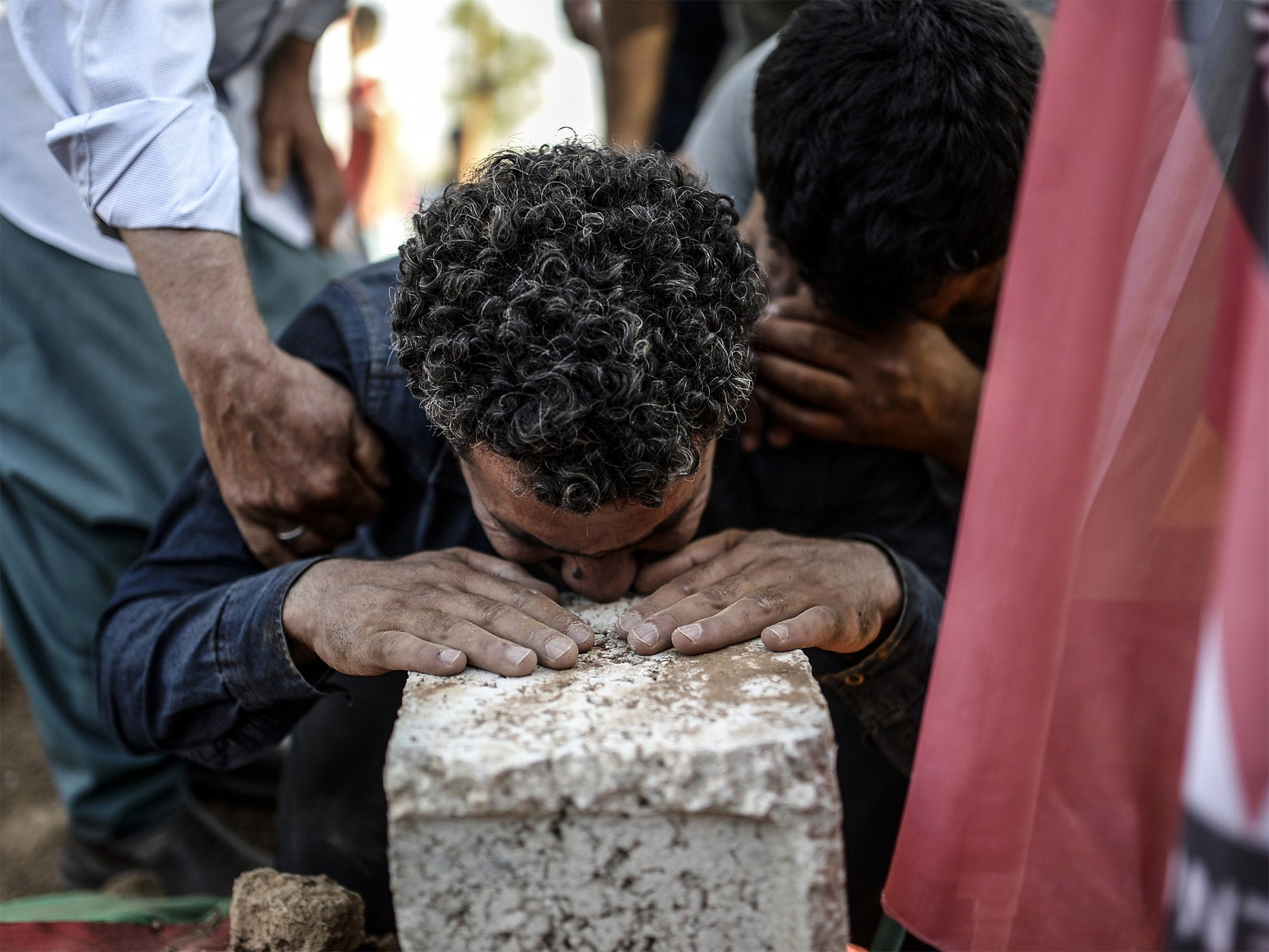 A man mourns during the funeral ceremony for victims of the suicide bomb attack in Suruc