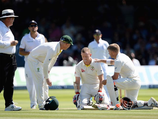 Chris Rogers of Australia is checked on by Brad Haddin and David Warner during the second Test