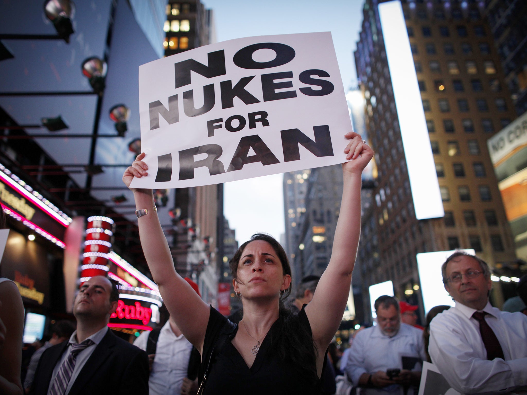 A woman holds a poster as she takes part in a rally on Times Square in New York opposing the nuclear deal with Iran (AP)