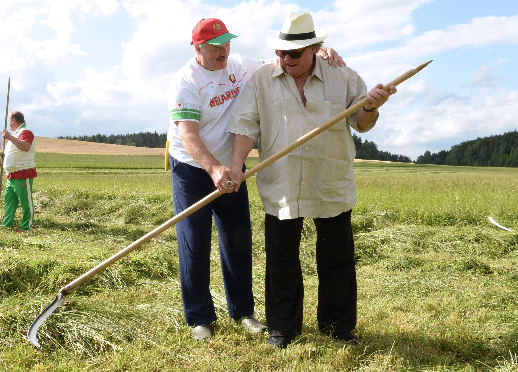 Belarus' President Alexander Lukashenko (L) teaches French actor Gerard Depardieu how to scythe at his official residence Ozerny, outside Minsk