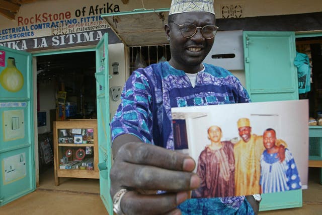 Malik Obama, the older brother of Barack, holds an undated picture outside his shop in Siaya in eastern Kenya