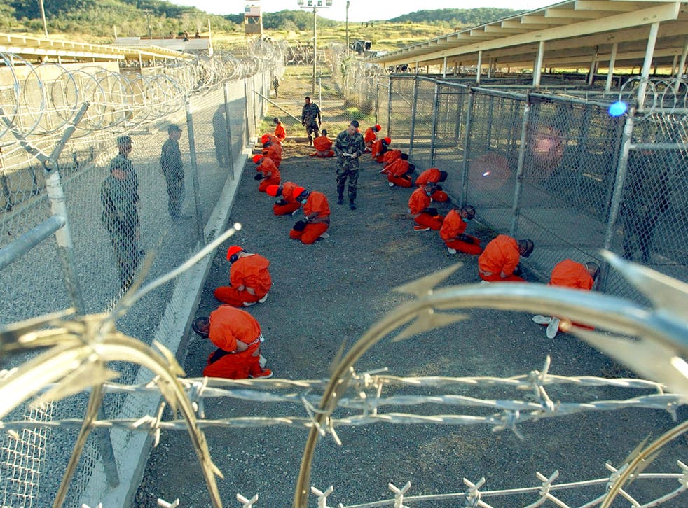 Military Police guard Taliban and al Qaeda detainees in orange jumpsuits 11 January 2002
