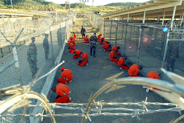 Military Police guard Taliban and al Qaeda detainees in orange jumpsuits 11 January 2002