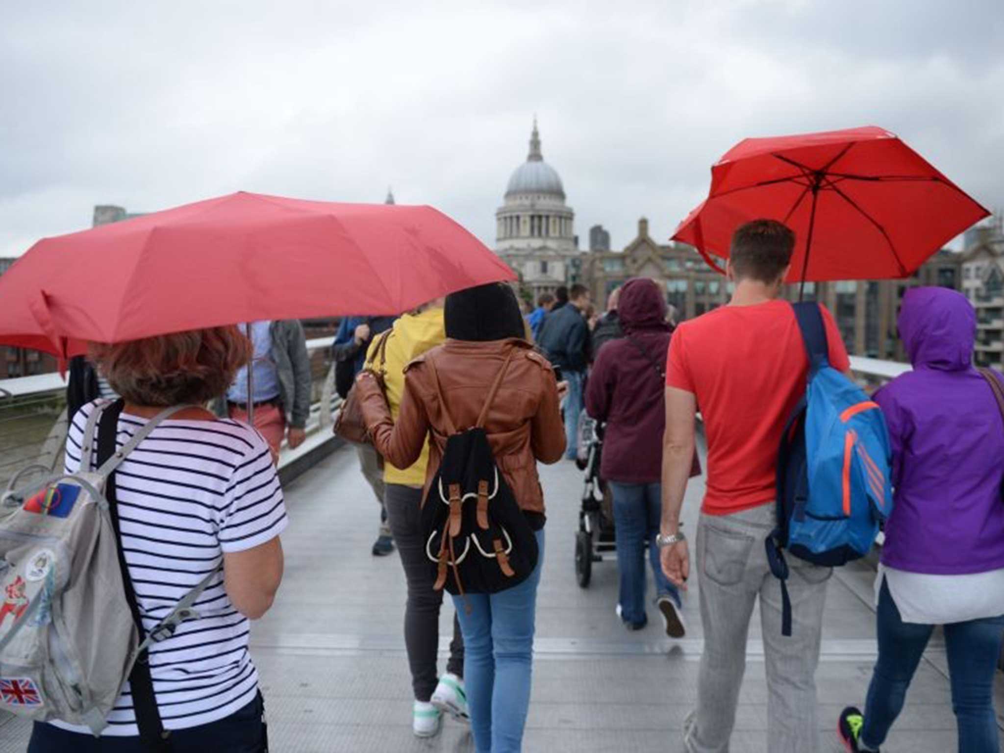 Tourists in London sheltering from the capital's weather