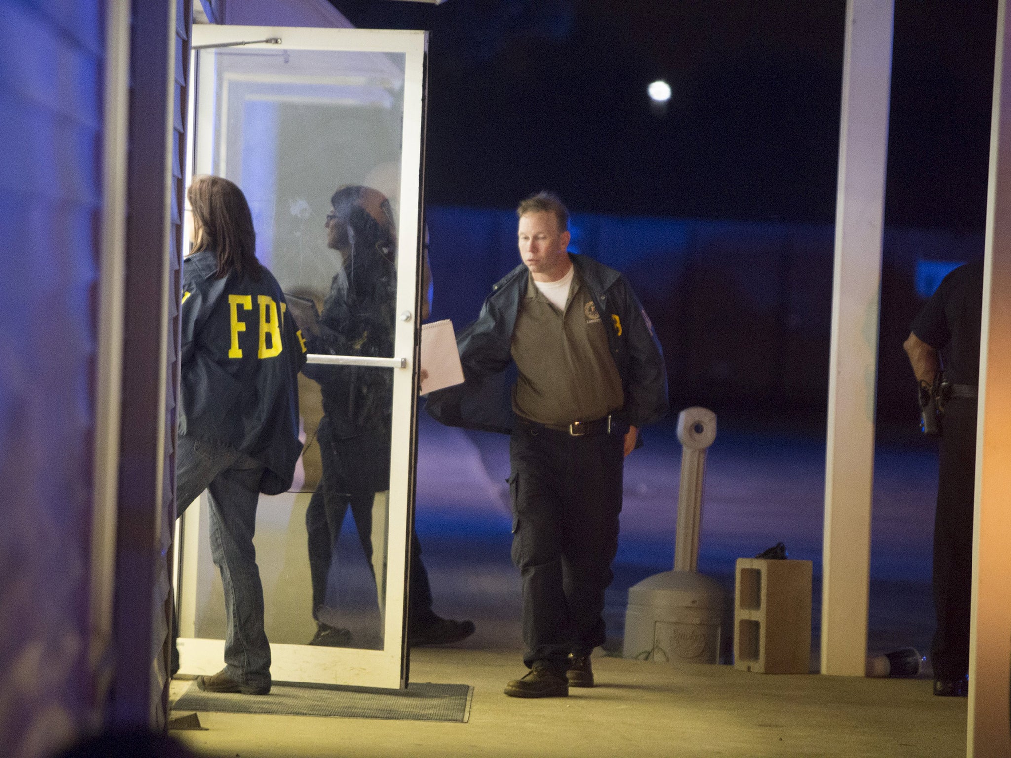 FBI officials enter a building near the movie theatre where a man opened fire on film goers