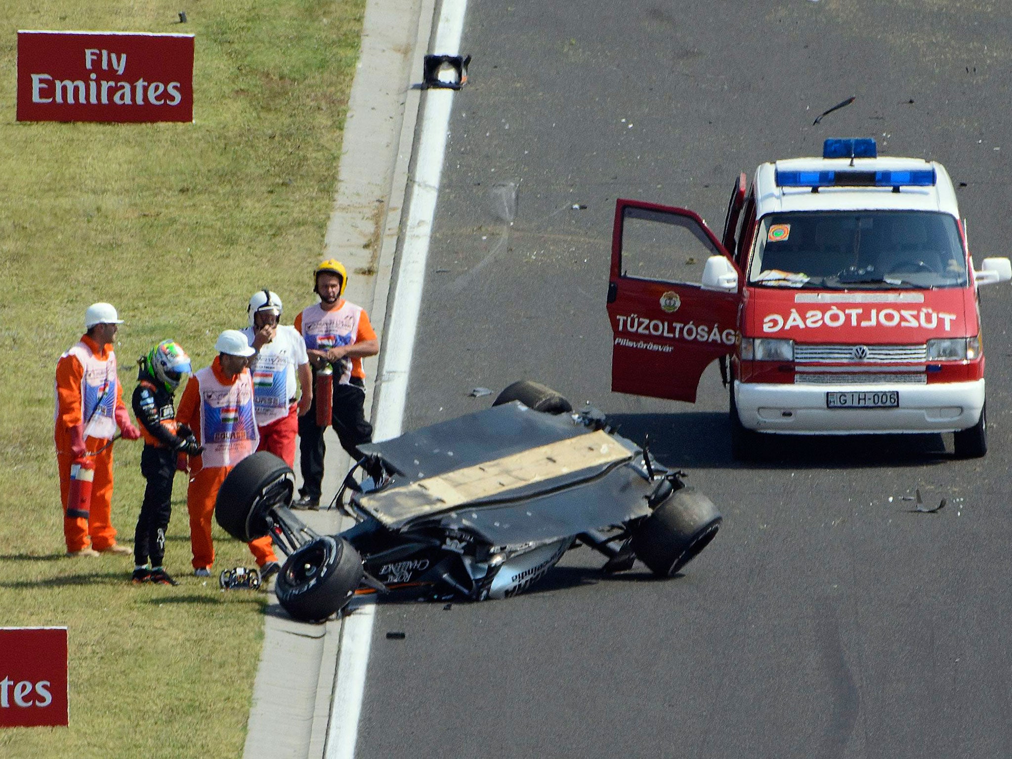 Perez observes the wreckage after escaping the damaged car