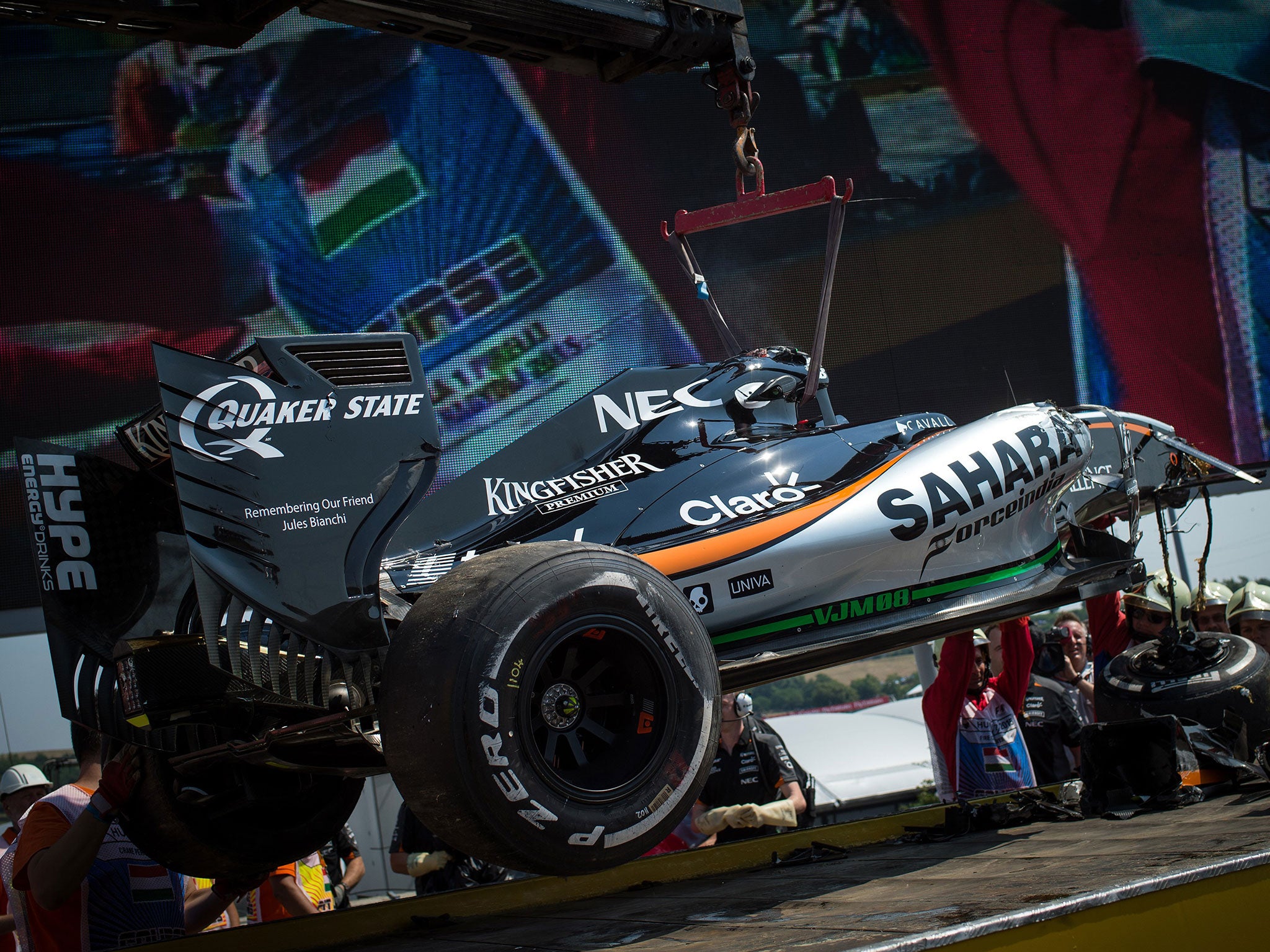 Sergio Perez's damaged Force India is brought back to the pits