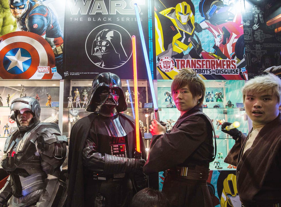 24 July 2015: Participants wearing costumes depicting their favourite characters, including Star Wars villain Darth Vader (C), pose at the 17th Ani-Com and Games exhibition in Hong Kong. The five-day festival of games, comics, animation and cosplay runs u