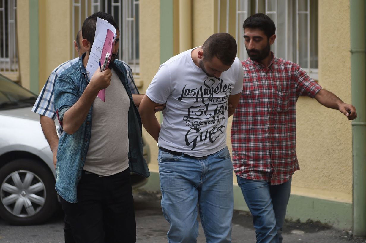 Turkish plain clothes police officers escort a suspected member of the Islamic State (IS) group at a hospital for a medical check-up on July 24