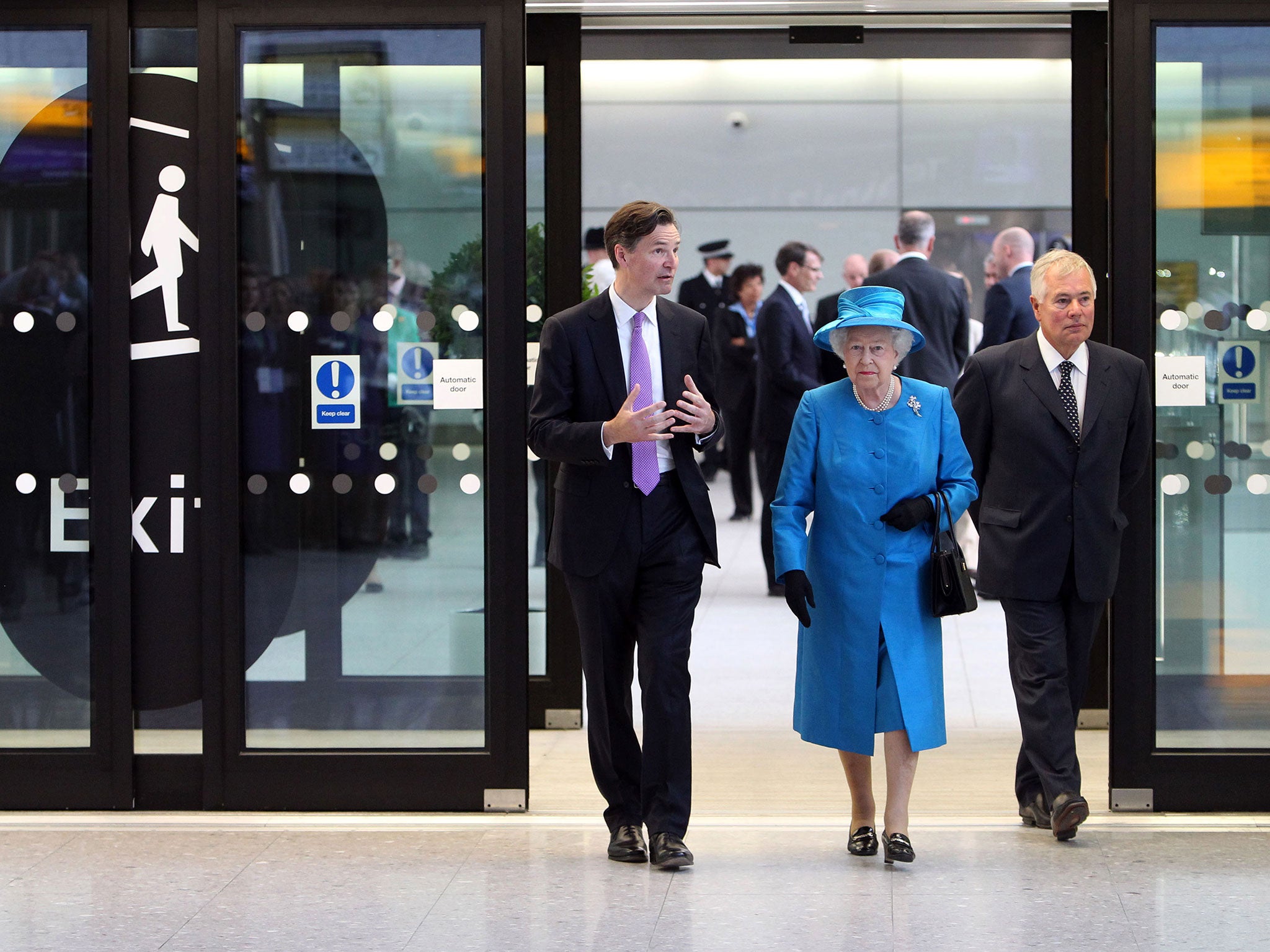 Queen Elizabeth II is shown around the new Terminal 2: The Queen's Terminal by Development Director for Terminal 2 and CEO Designate John Holland-Kaye