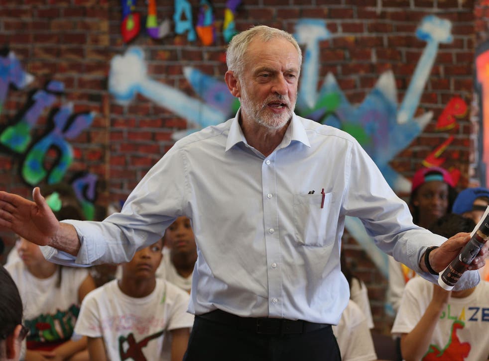 Labour leadership contender Jeremy Corbyn presents pupils with certificates after they perform in a play on their last day of school at Duncombe Primary School on July 16, 2015
