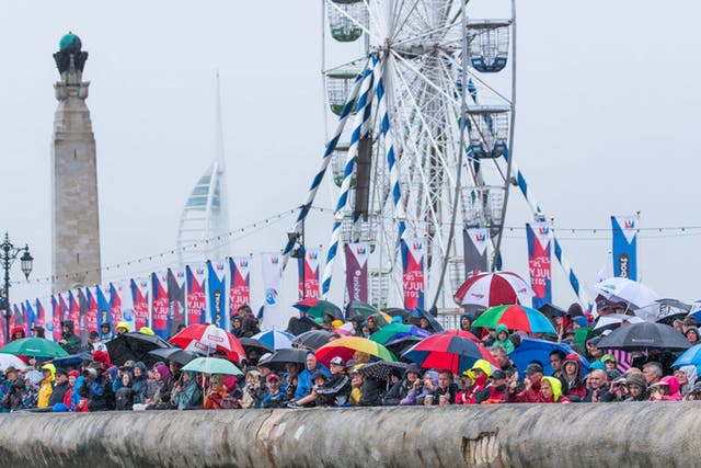 Les parapluies de Portsmoutb. Umbrellas raised as a crowd on the sea wall at Southsea watches the six boats in the America’s Cup World Series go through their paces.