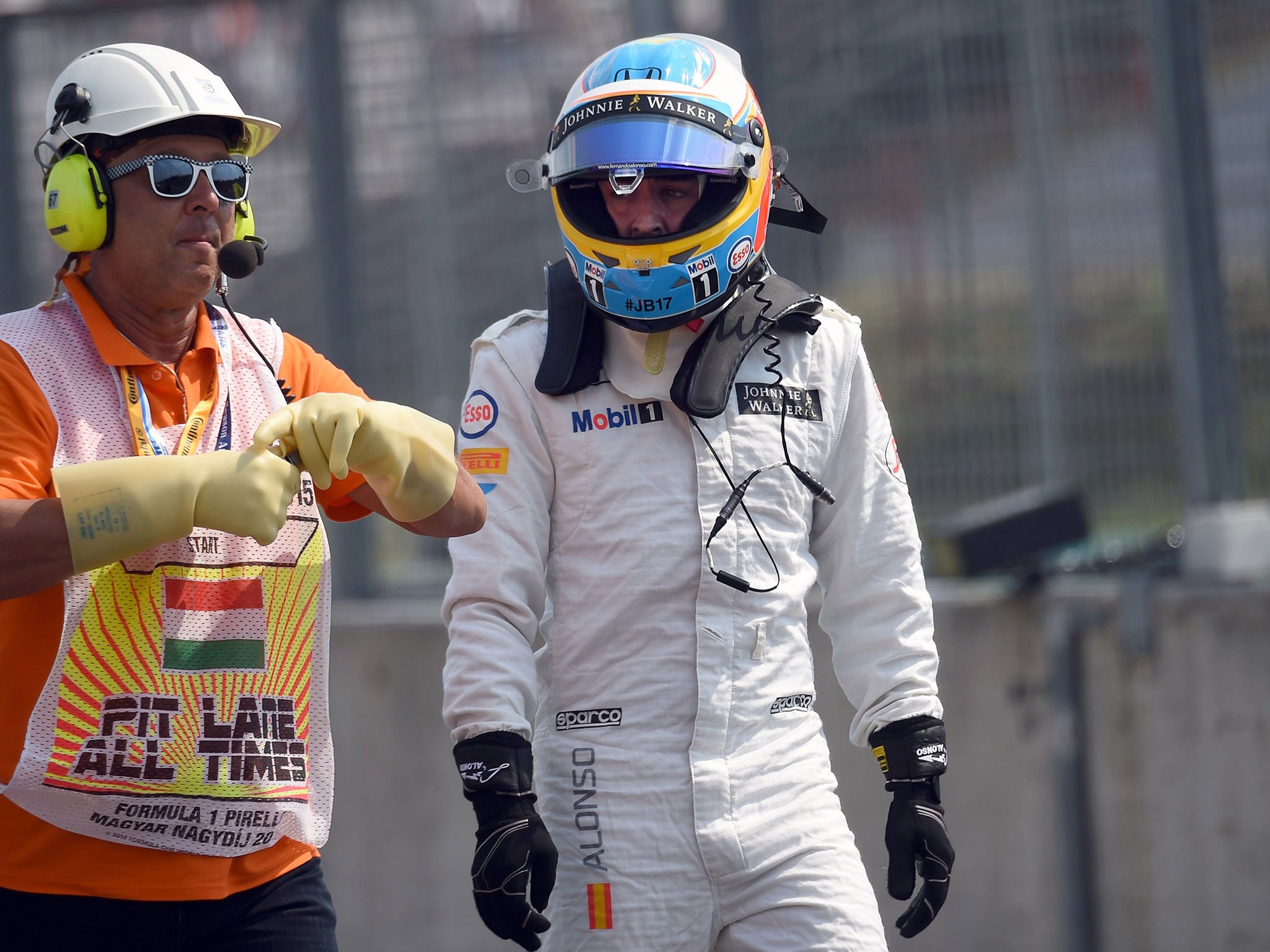 Fernando Alonso walks back to the pits after being told he cannot continue