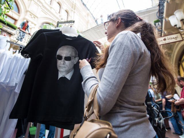 A woman shops for a t-shirt with Putin's face on it at a department store in Moscow