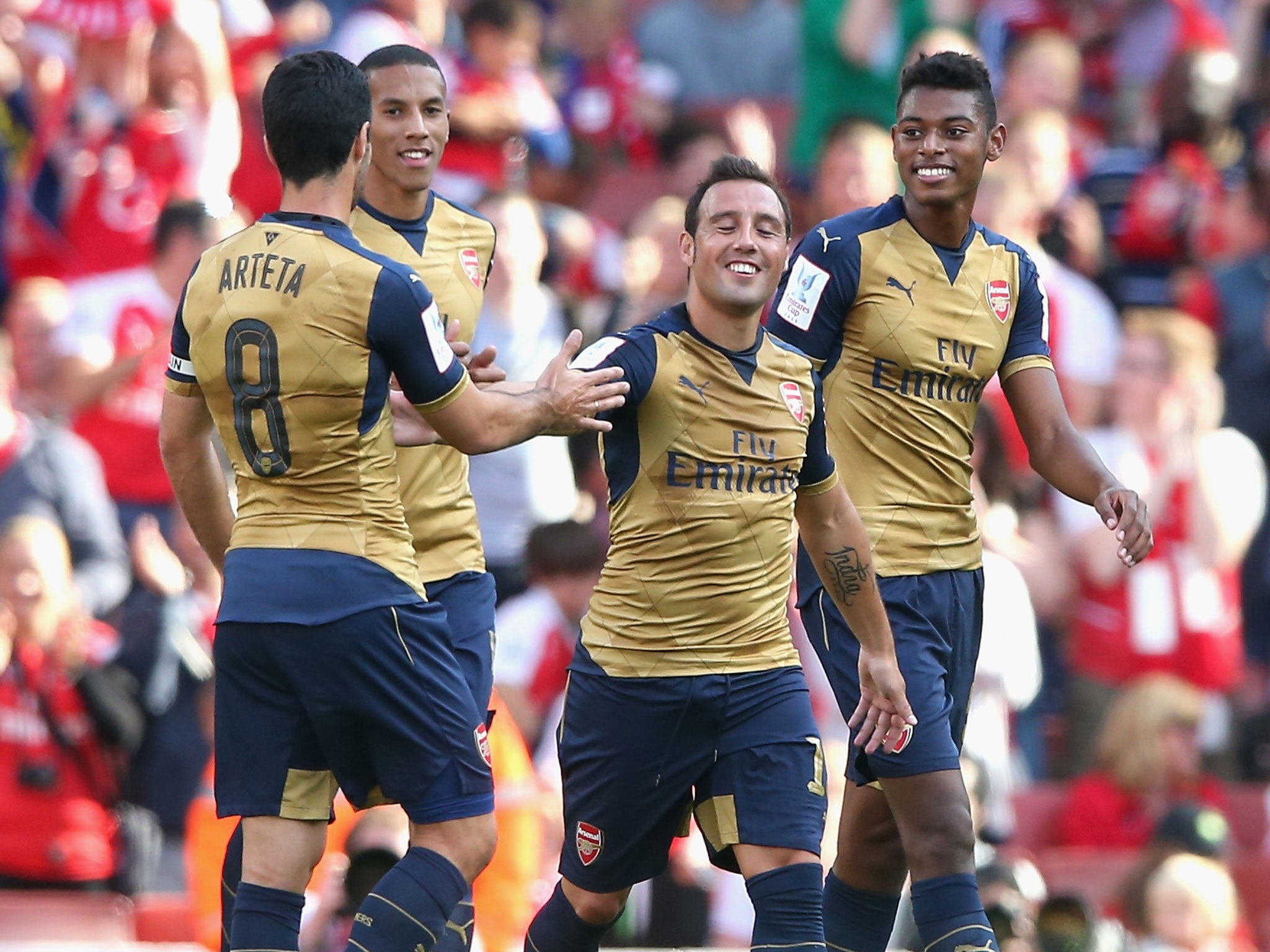 Santi Cazorla celebrates with his Arsenal team-mates after scoring a free-kick against Lyon