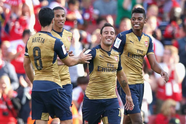 Santi Cazorla celebrates with his Arsenal team-mates after scoring a free-kick against Lyon