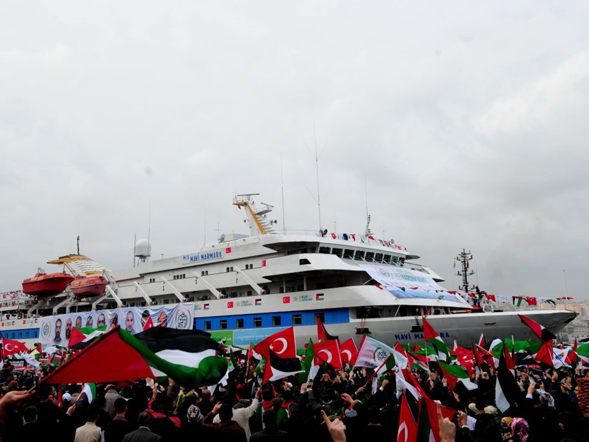 People wave Palestinian and Turkish flags as they welcome the Mavi Marmara ship at Istanbul's Sarayburnu port in 2010. The Turkish ferry was the target of a deadly raid by Israeli commandos when it tried to deliver aid to Gaza.