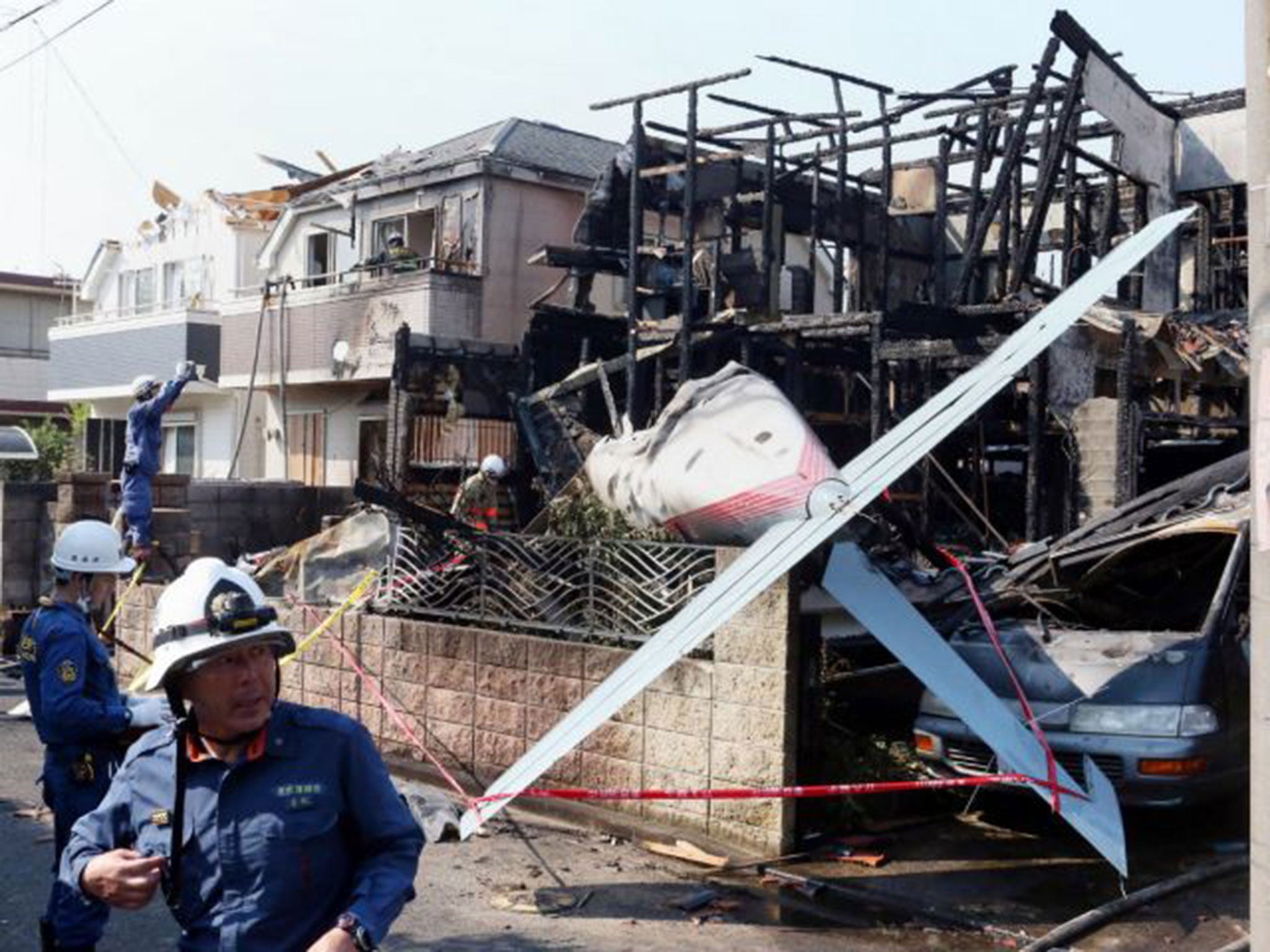 The light aircraft's tail protrudes from the burnt out shell of the house (AFP)