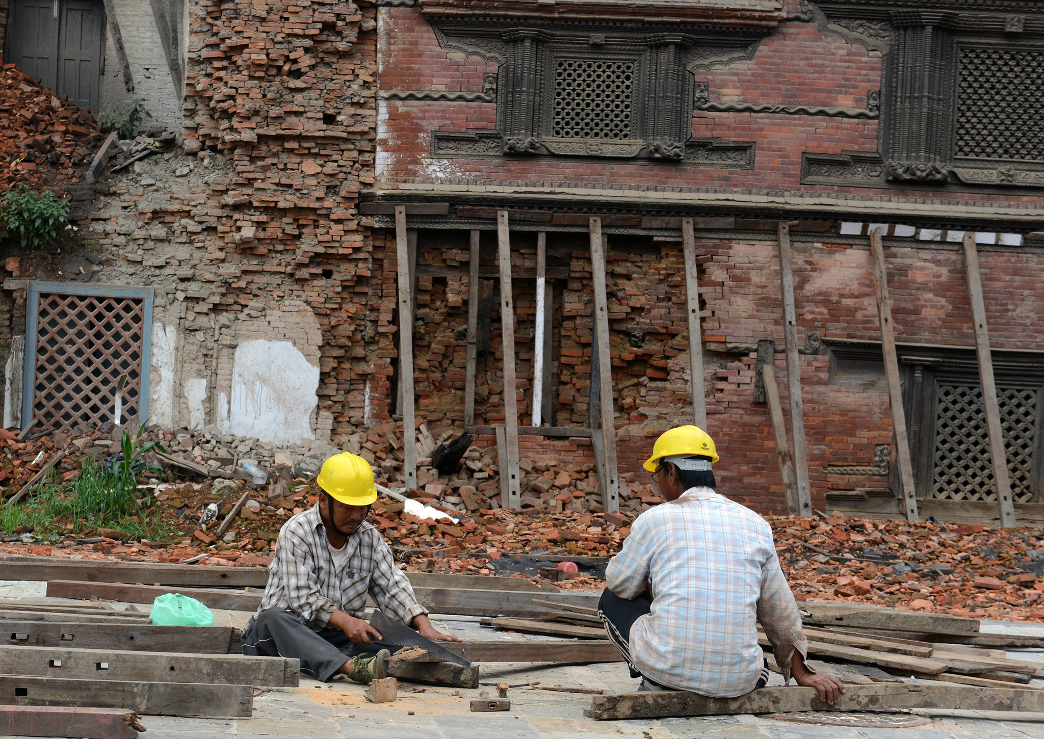 Workers renovate heritage sites in Basantapur Durbar Square in Kathmandu on July 21, 2015 that were destroyed by earthquakes in April and May
