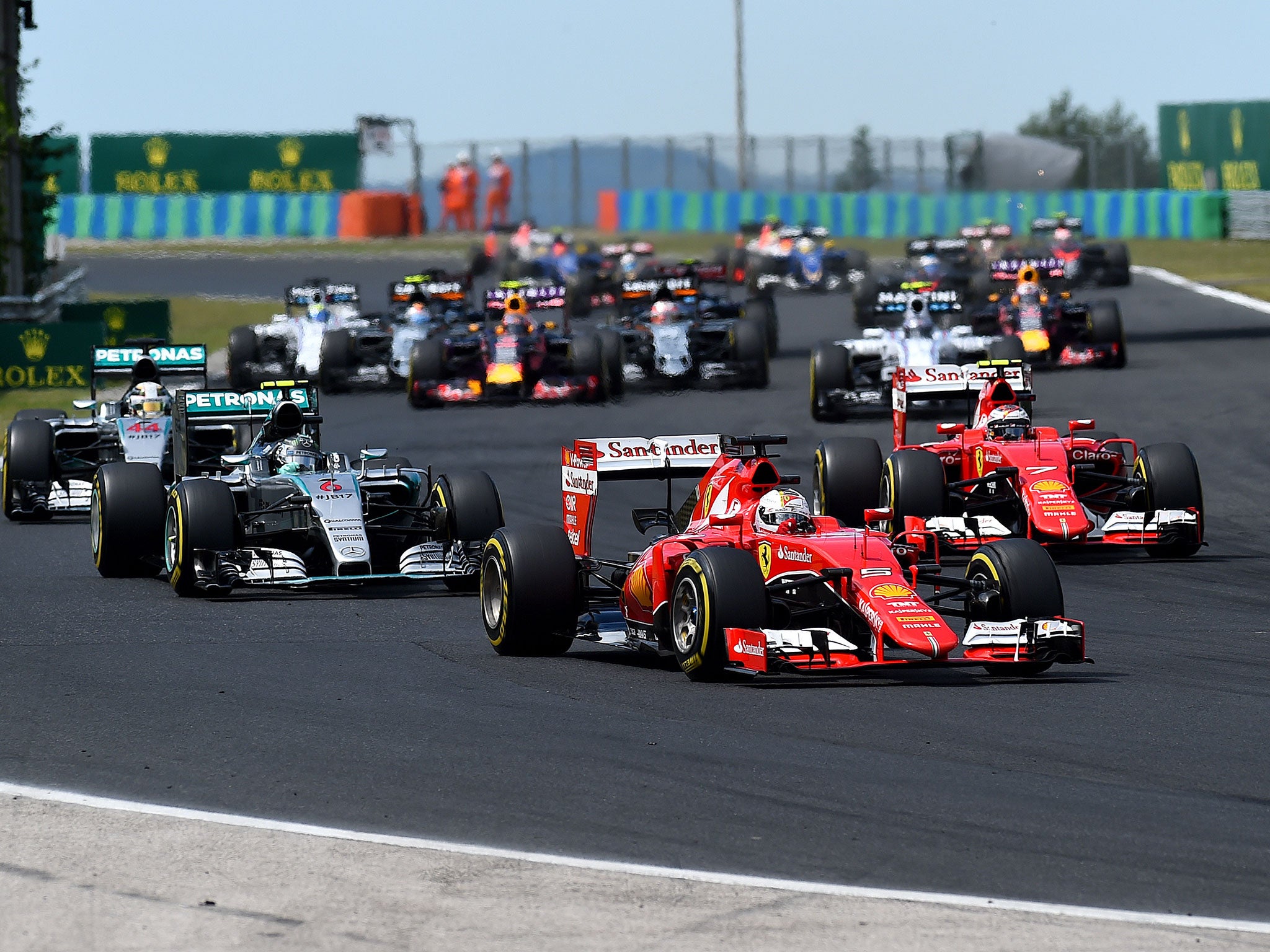 Sebastian Vettel of Germany and Ferrari leads Nico Rosberg of Germany and Mercedes GP, Lewis Hamilton of Great Britain and Mercedes GP and Kimi Raikkonen of Finland and Ferrari into the second corner