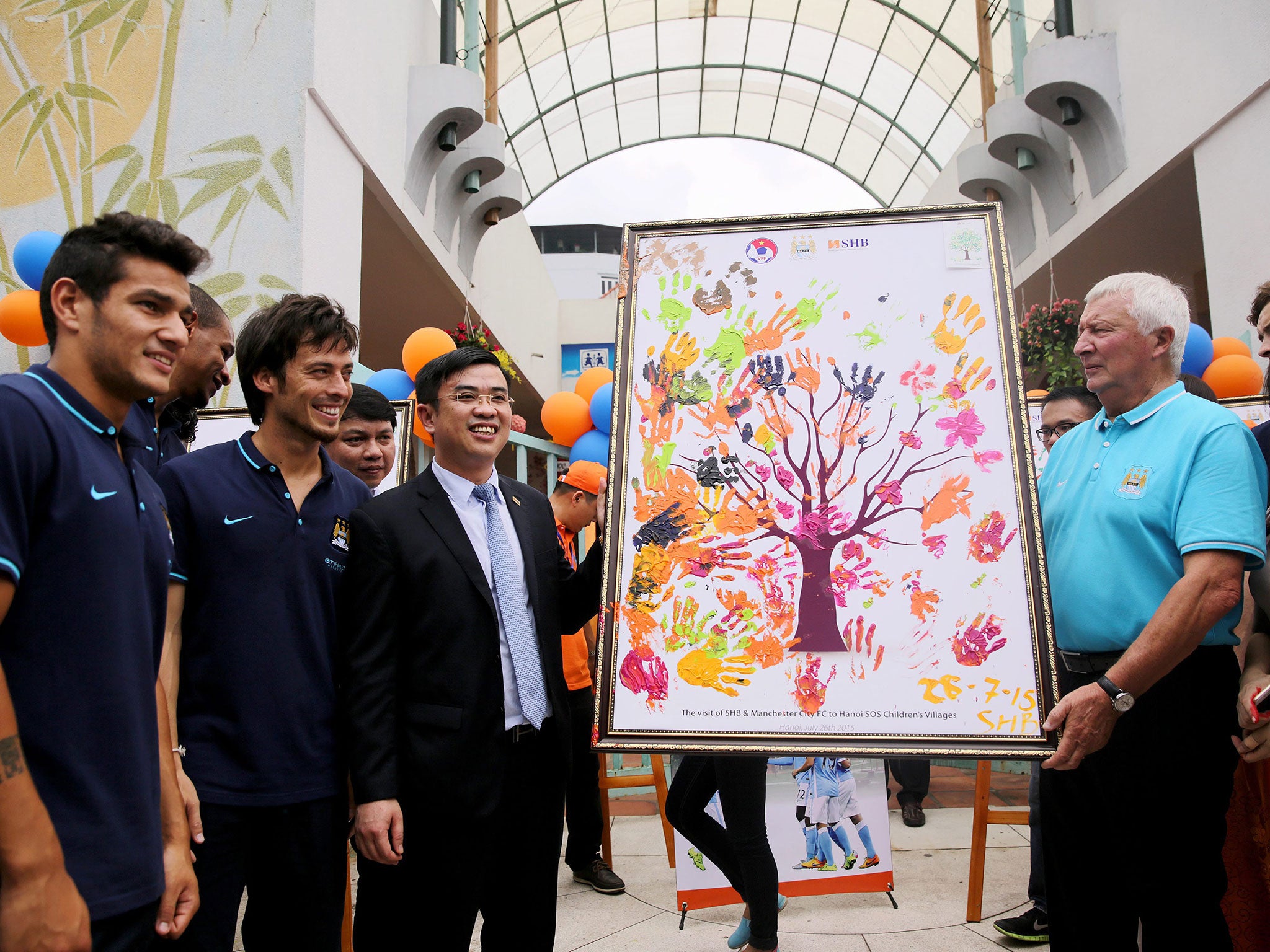 Manchester City players Marcos Lopes and David Silva join Saigon-Hanoi Bank general director Nguyen Van Le and City ambassador Mike Summerbee at a promotional event in Hanoi