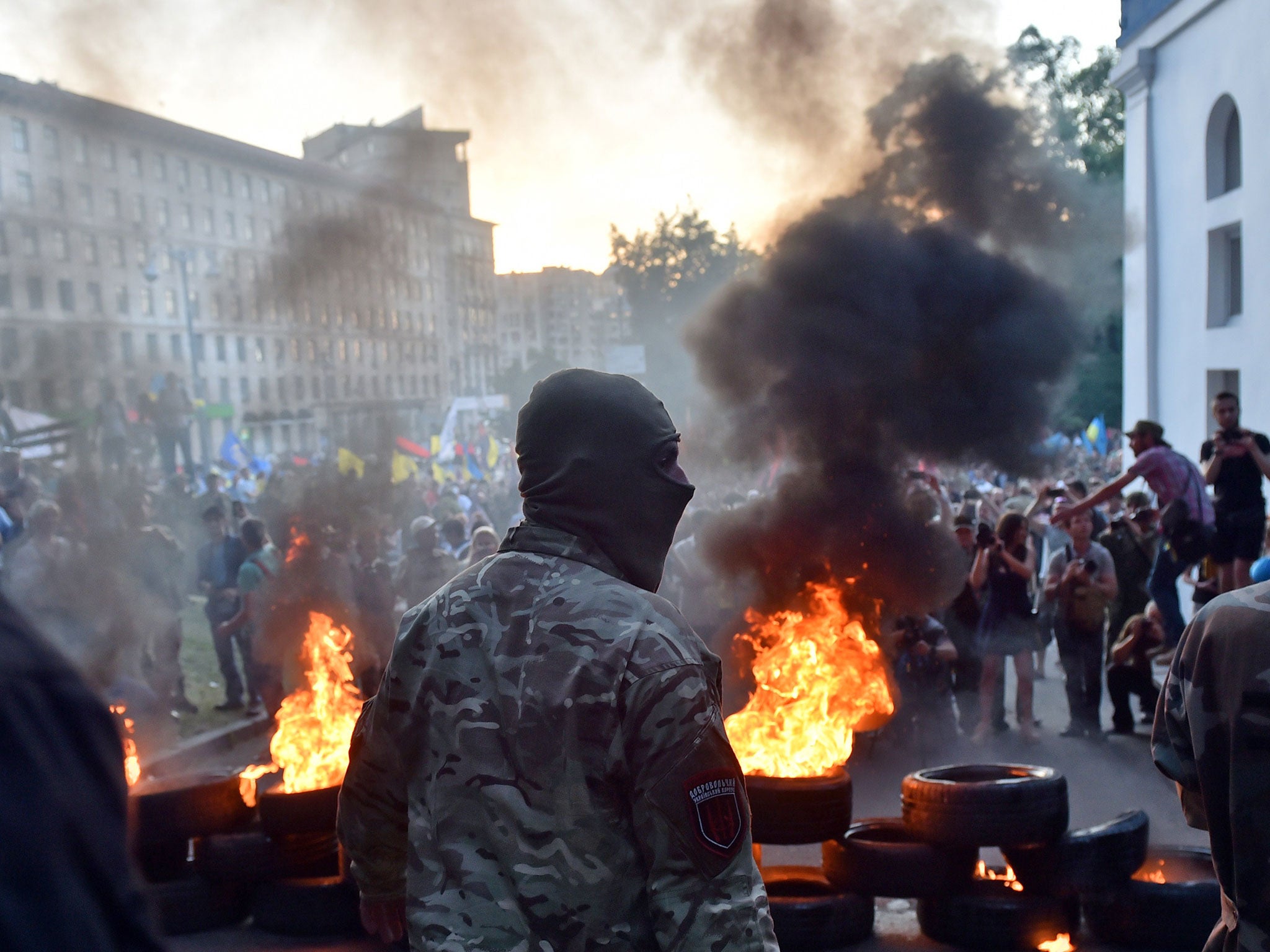 A far-right activist stands in front of a blaze of tyres near the Ukrainian government building in central Kiev