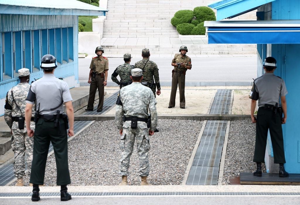 North and South Korean soldiers, citizens of countries that are still technically at war, stare at each other across the border in the demilitarised zone that separates the two Koreas