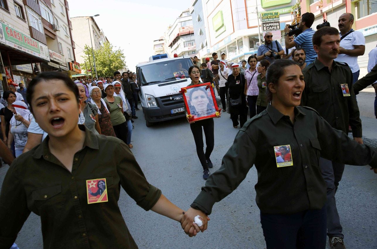 Far left-wing activists shout slogans as they escort the coffin of Gunay Ozarslan