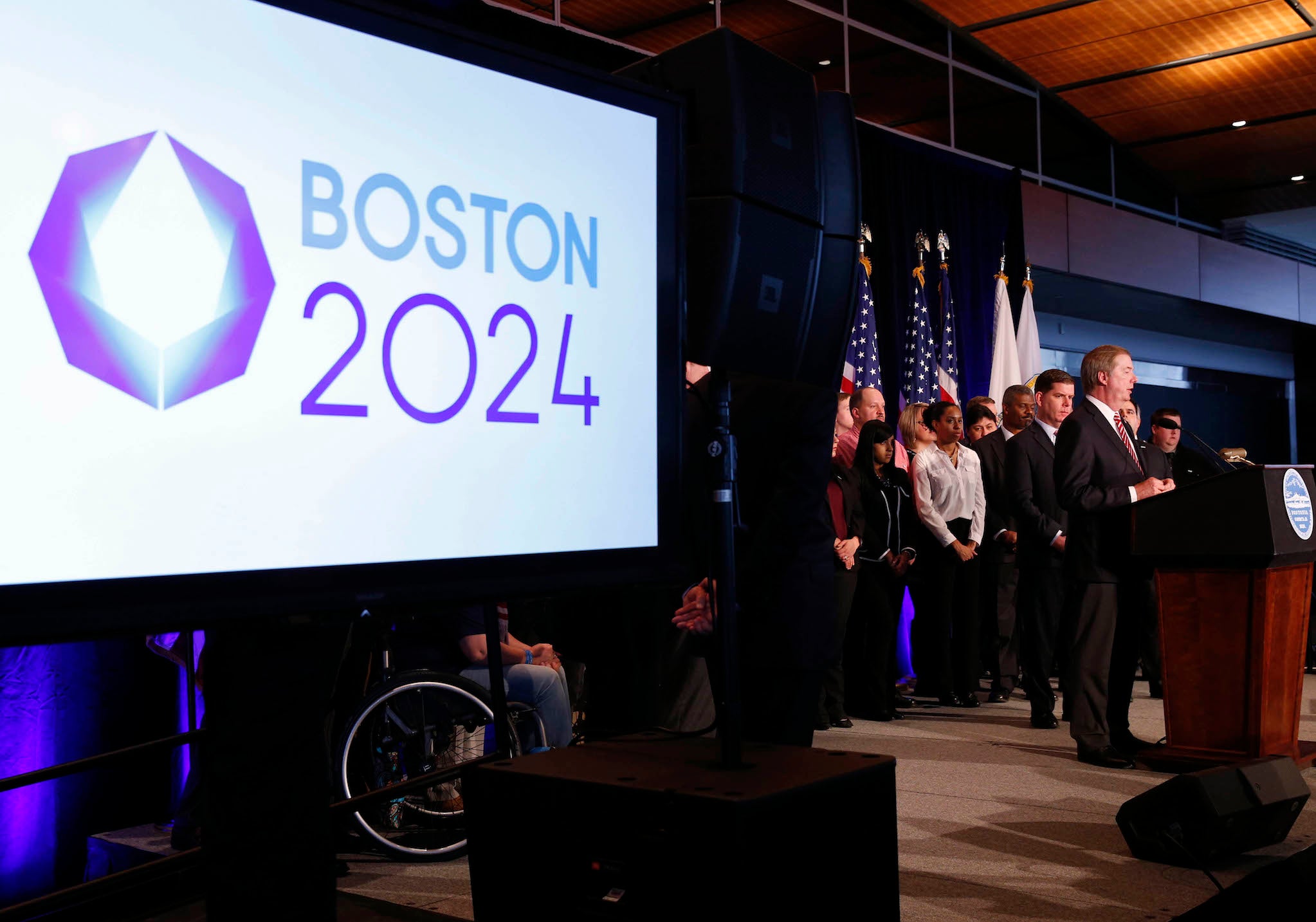 Lawrence Probst, flanked by Martin Walsh (left) , talks about selecting Boston as its applicant to host the 2024 Olympic and Paralympic Games.