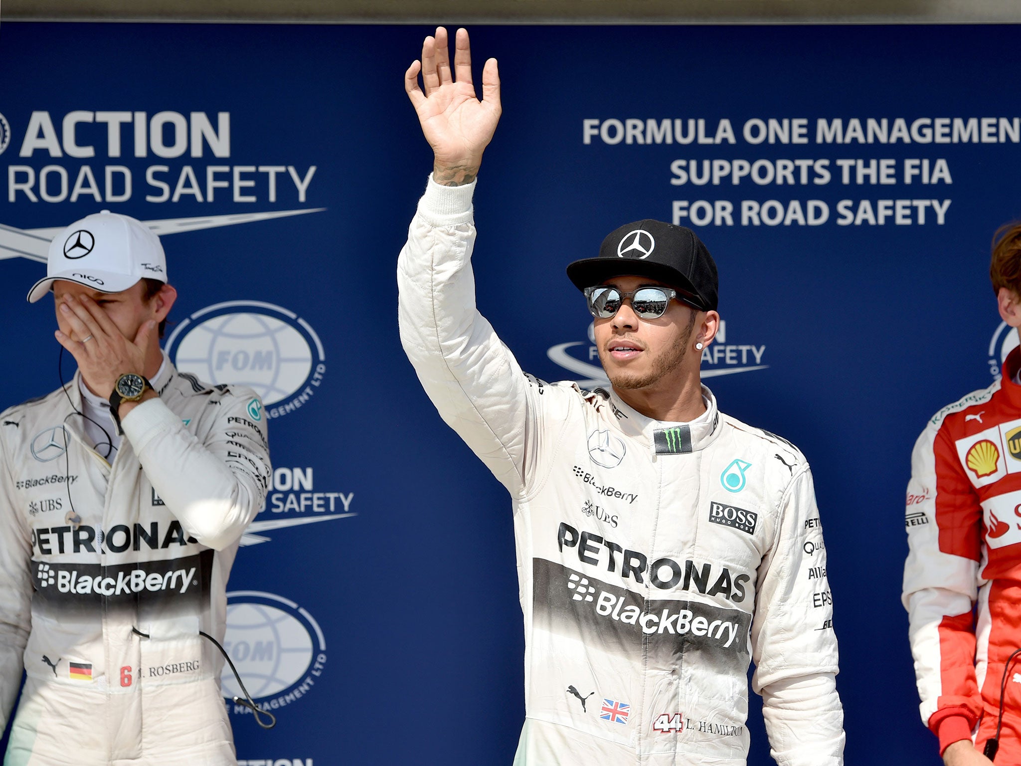 Nico Rosberg grimaces as Lewis Hamilton waves to the crowd