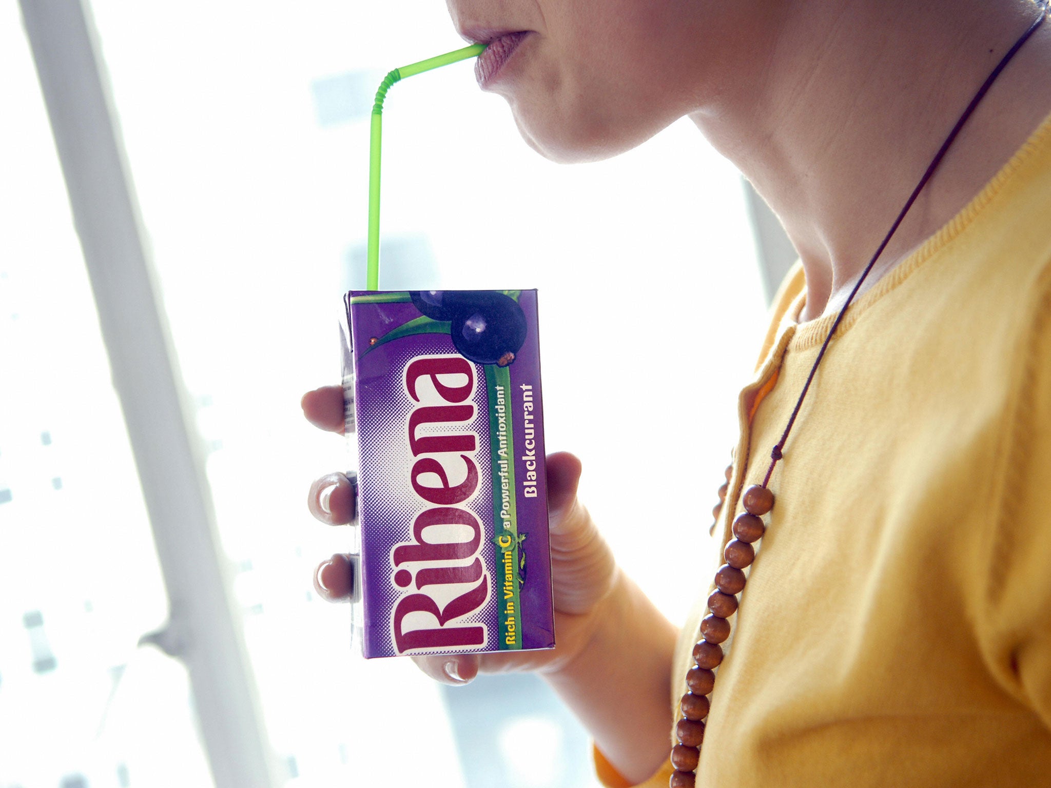 A woman sips a Ribena drink