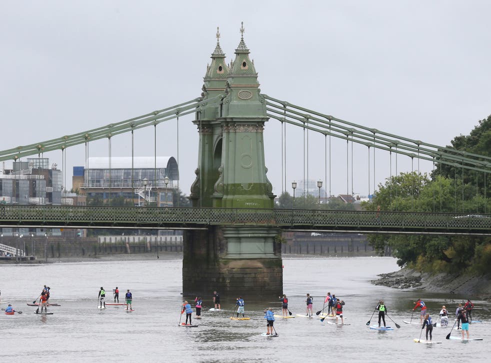 Paddle boarders approach Hammersmith bridge as they participate in the Laureus Stand up for good Thames Challenge on the river Thames in London