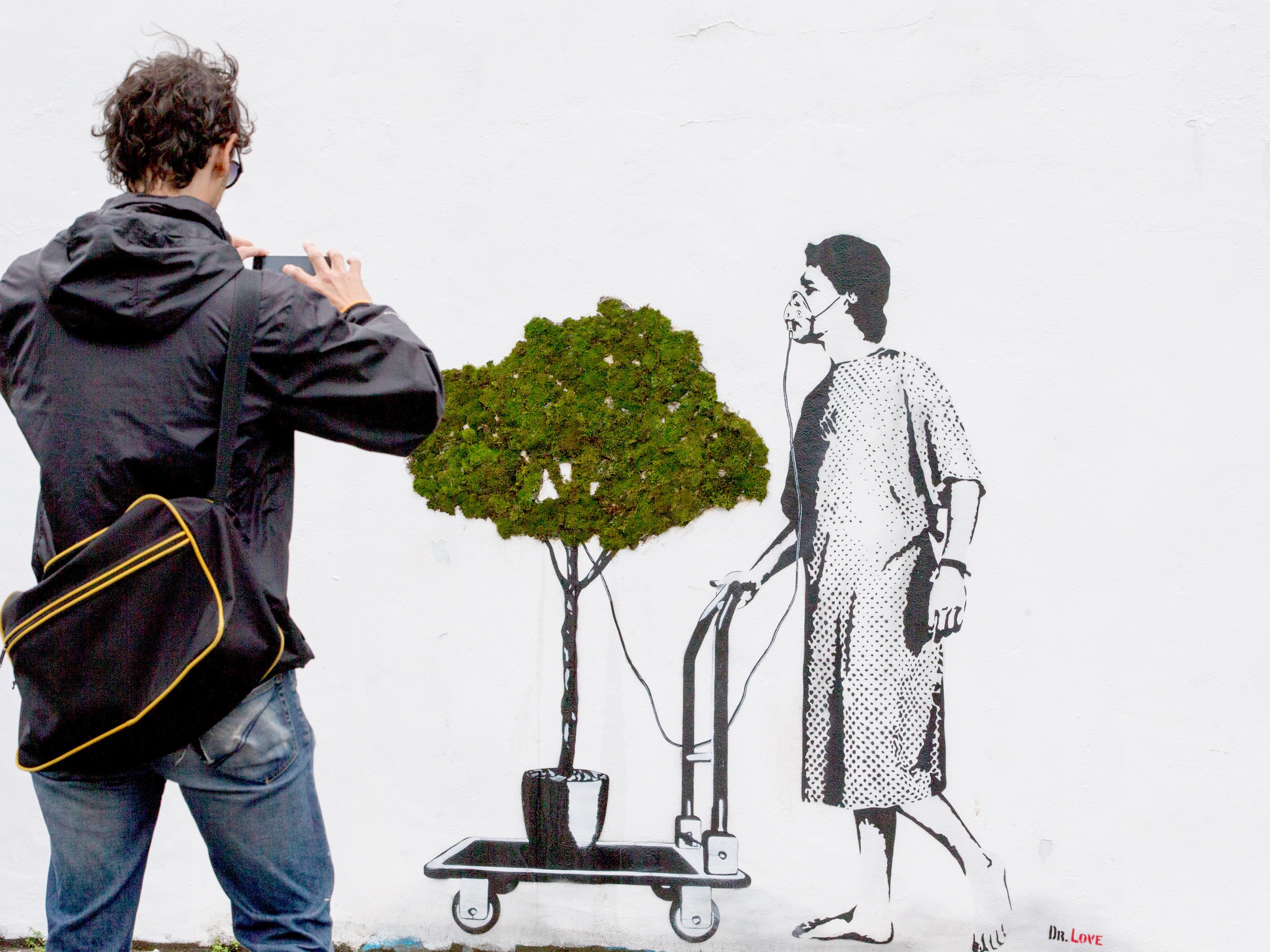 A man takes a photograph in front of a piece of street art as part of the ongoing Upfest 2015 festival being held in Bedminster on July 27, 2015