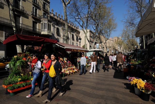 Tourists stroll down the famous Las Ramblas in Barcelona, near to where the shooting occured