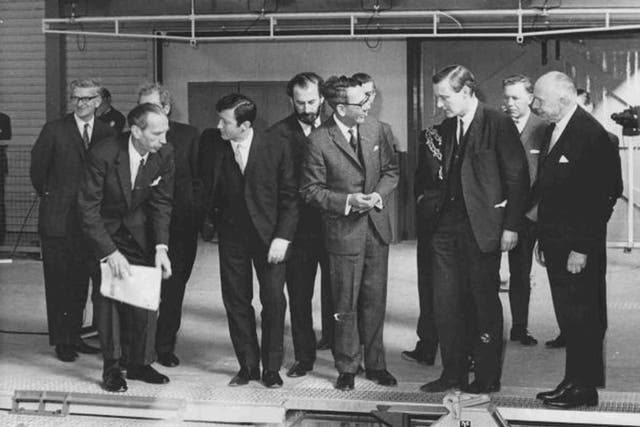 Macmillan, centre, shows the linear motor to the Minister of Technology, Tony Benn