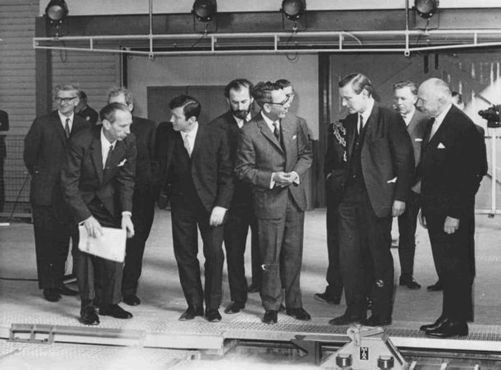 Macmillan, centre, shows the linear motor to the Minister of Technology, Tony Benn