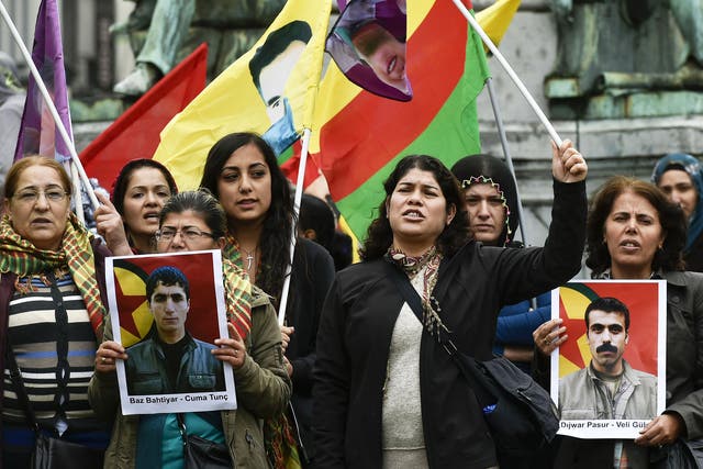 Demonstrators in Brussels on Tuesday holding pictures of the victims of a suicide bombing in the Turkish town of Suruc last week