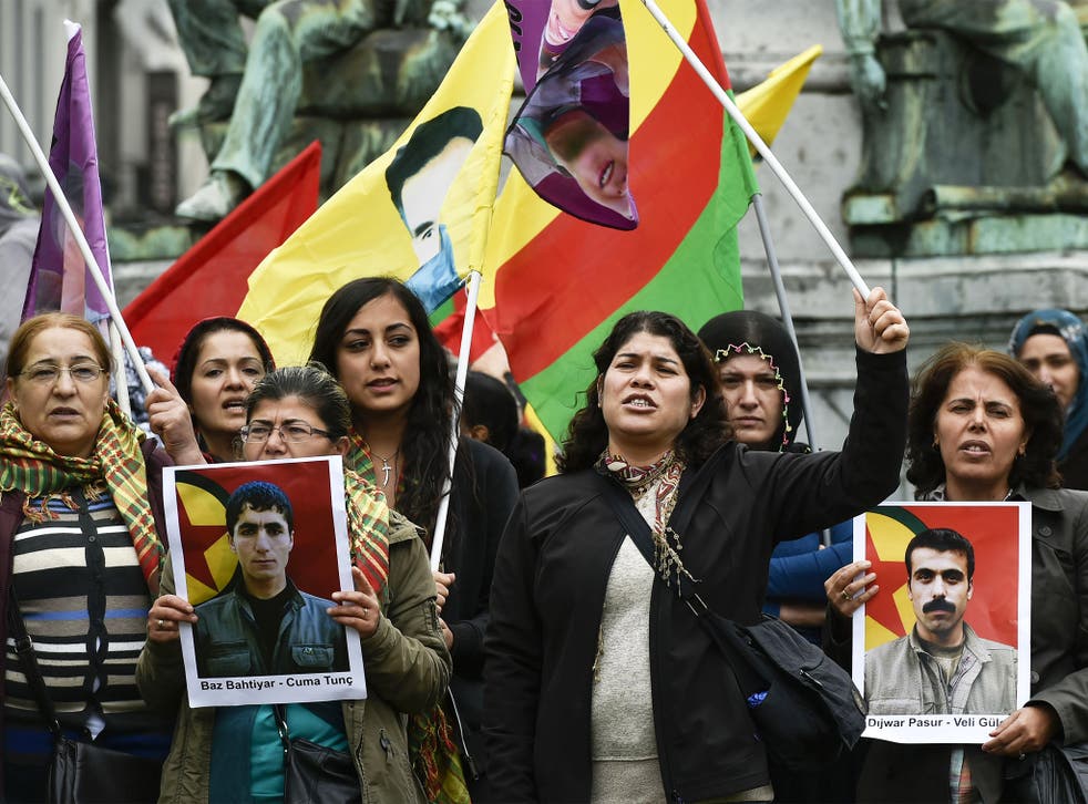 Demonstrators in Brussels on Tuesday holding pictures of the victims of a suicide bombing in the Turkish town of Suruc last week