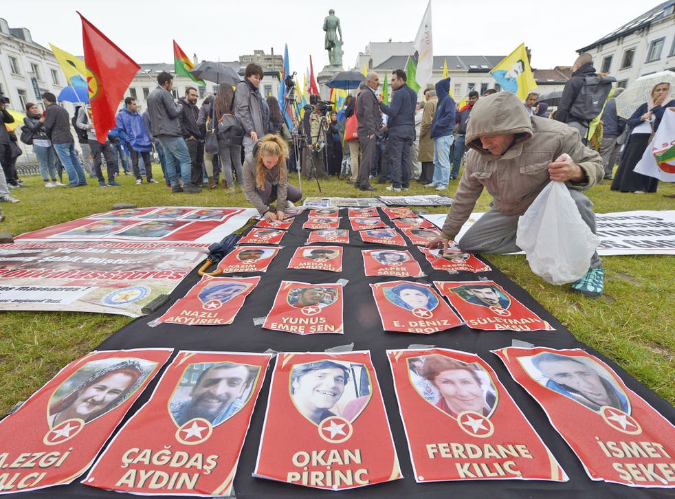 Demonstrators display pictures of victims of last week's suicide bombing in Suruc, at a protest in Brussels on Tuesday