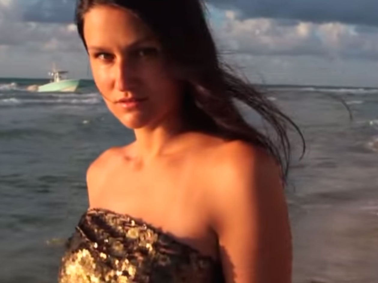 The boat carrying the migrants can be seen in the back of the model's video shoot