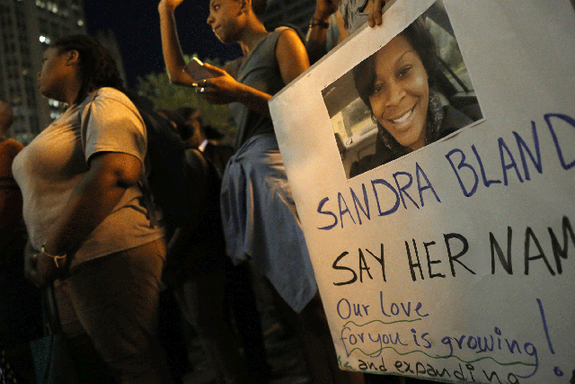 A demonstrator holds a Sandra Bland sign during a vigil on 28 July in Chicago